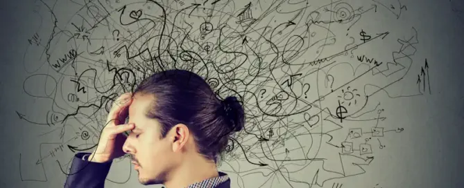 man holding head with black graphics showing how overwhelmed he is