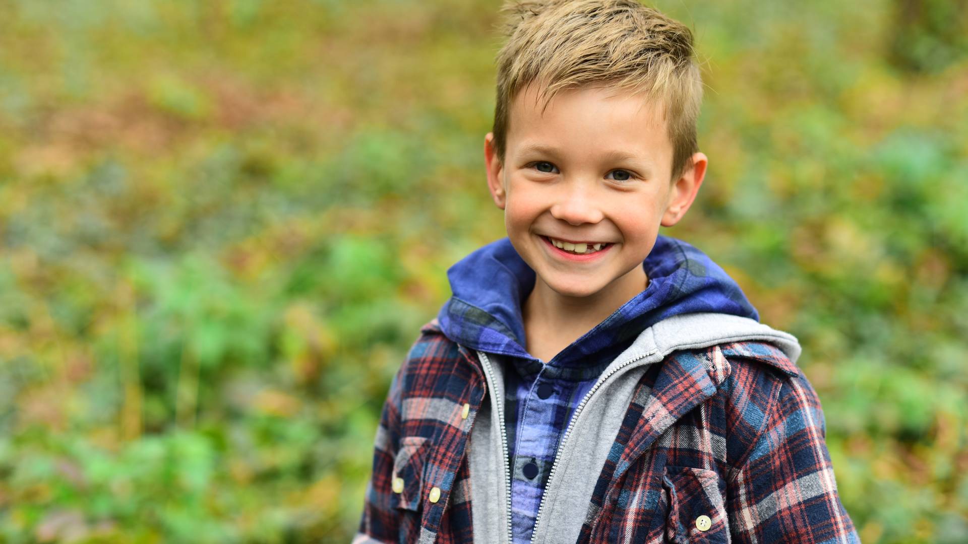 AdobeStock_227300626 a child outside smiling at the camera