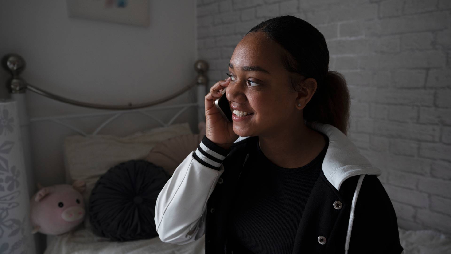 a teenager smiling while on the phone