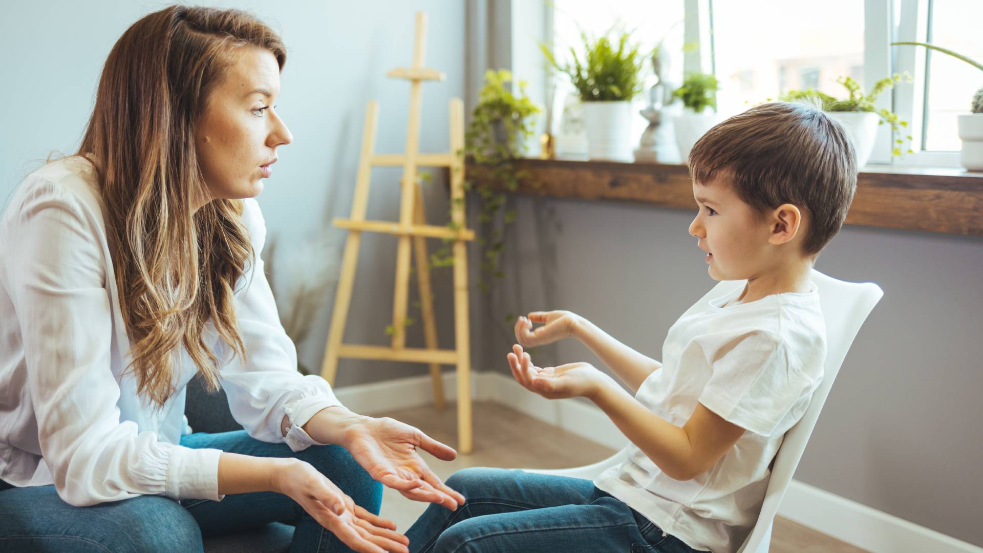 Causes of ADHD a woman and a child speaking while sitting and shrugging