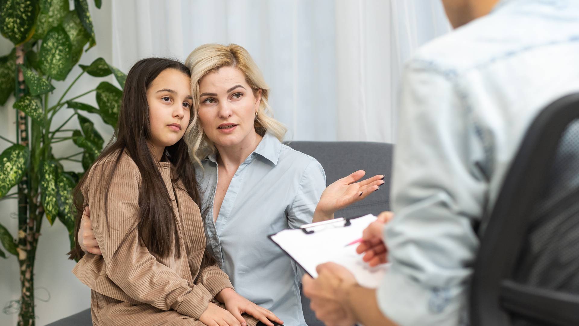 What happens in an ADHD assessment_ a woman holding a child on her lap while they talk to a therapist