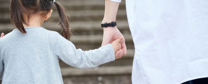 adult holding a child's hand