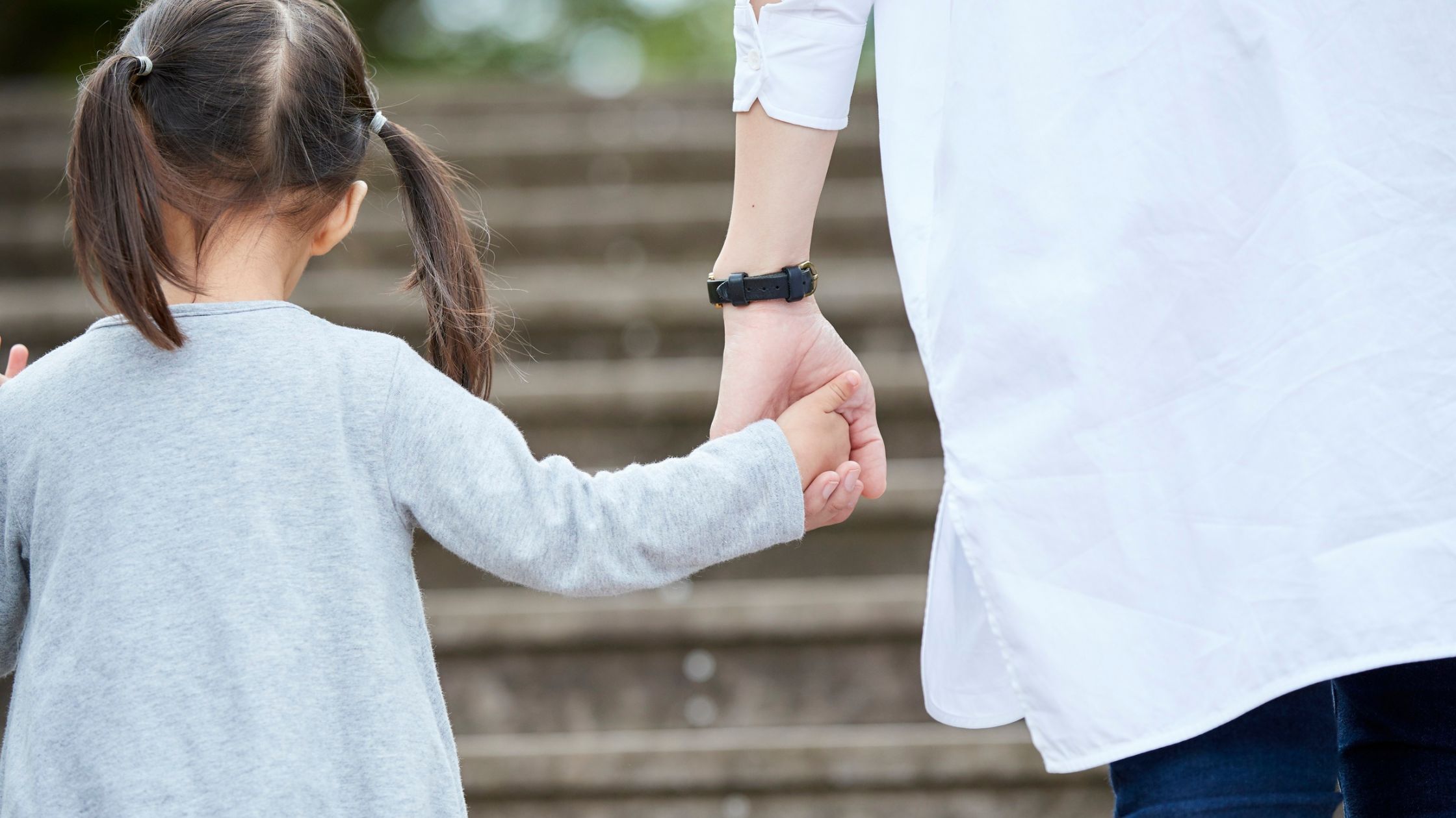 adult holding a child's hand